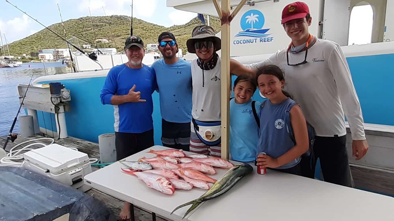 Crew and Guests behind a table of fish